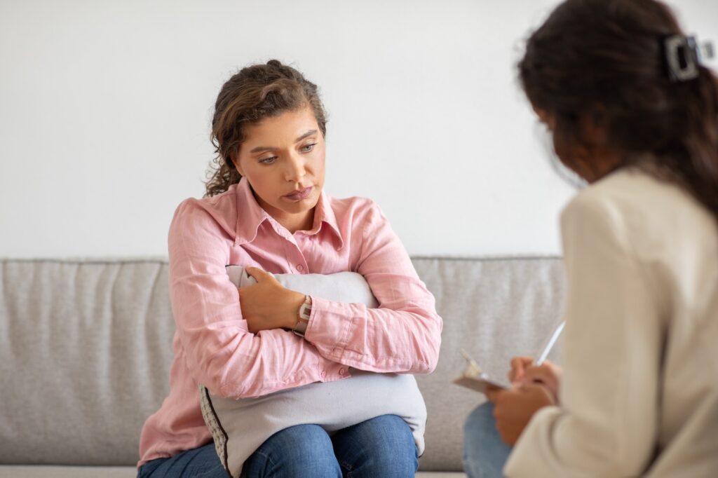 A,Young,Woman,,Dressed,In,Pink,,Sits,On,A,Couch