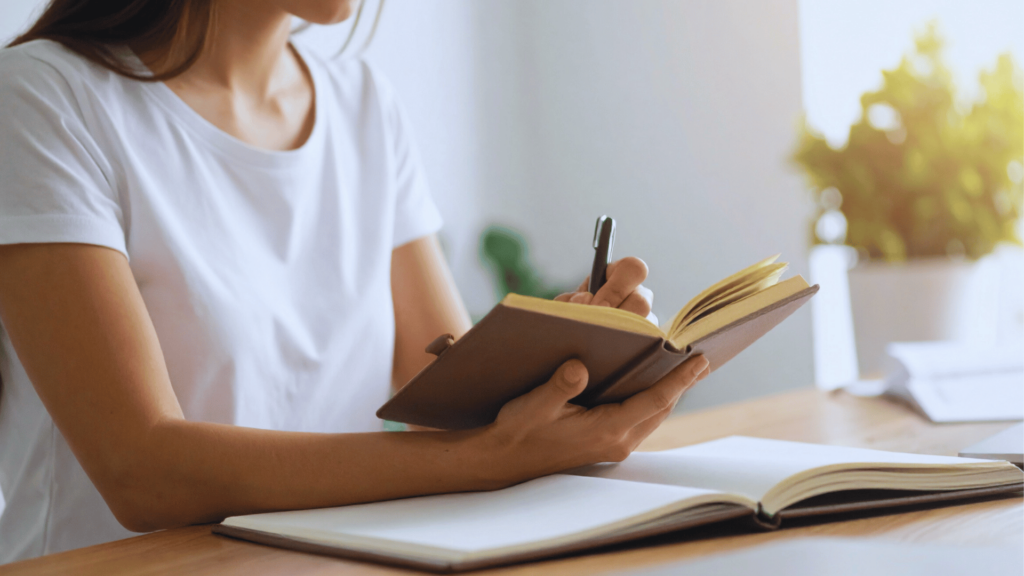 Image of a calendar, a journal, and a pen on a serene deskion.